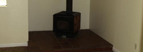 A black wood stove surrounded by tile